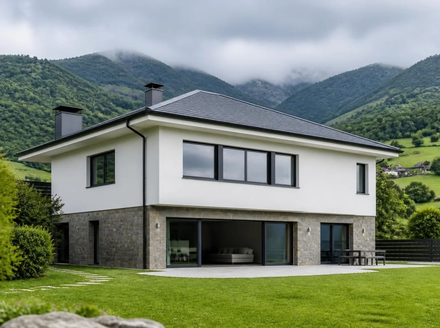 Vivienda con base de piedra y ventanas de PVC antracita entre montañas verdes de Asturias